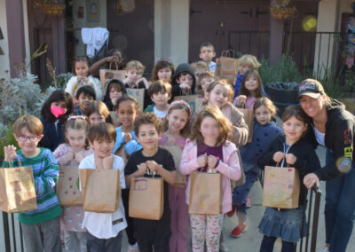 The entire first grade class pose with the lunch bags they assembled.