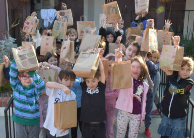 The first graders raise their lunch bags in a cheer!