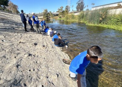 3rd graders take water samples from the river.