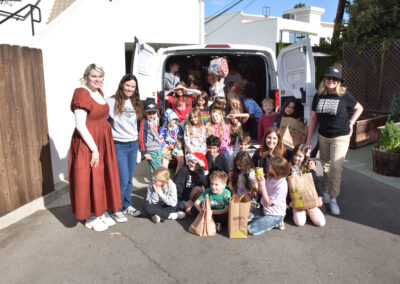 The 2nd grade class poses with the van full of their donations for delivery.